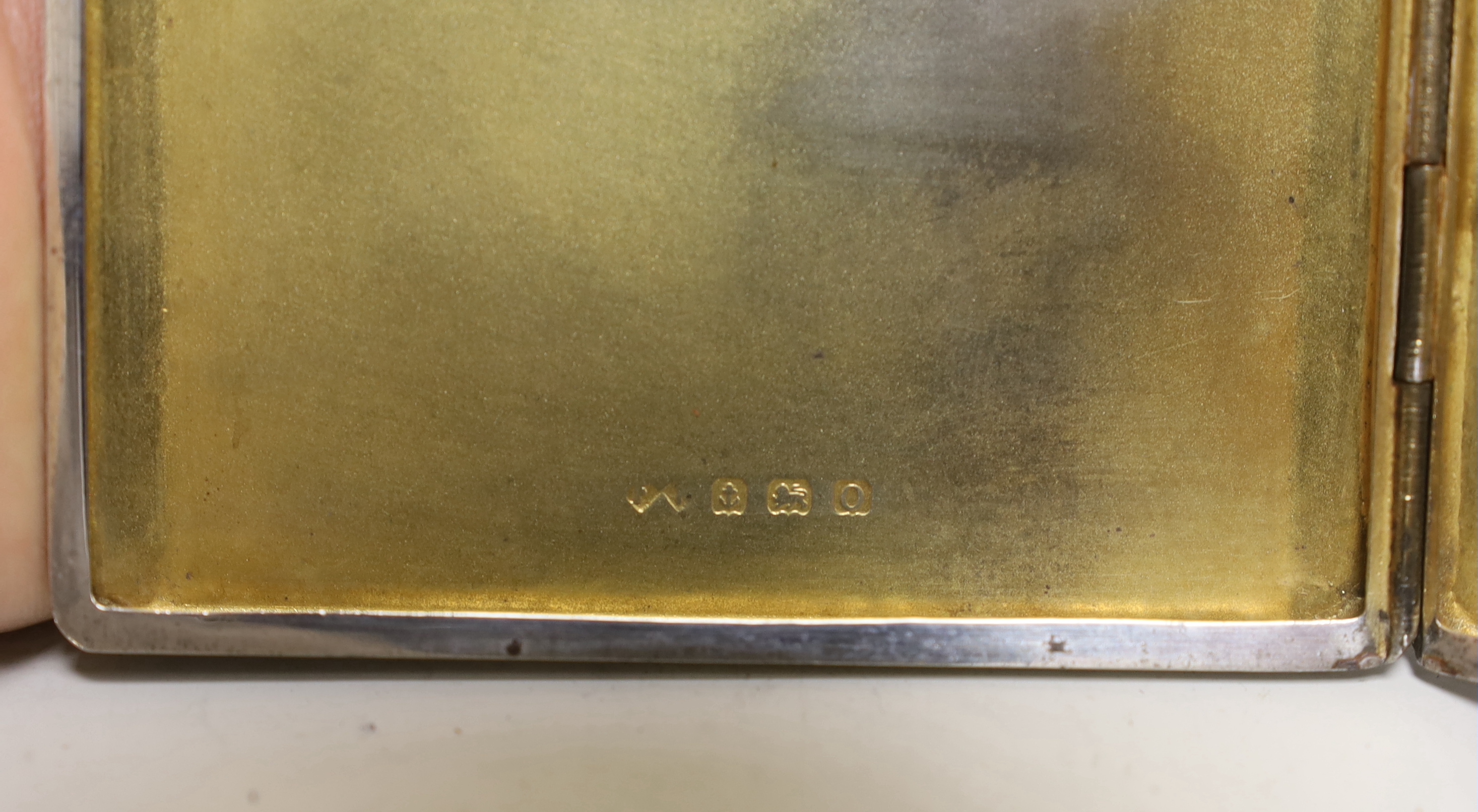 A George V engine turned silver cigarette case, 11.3cm a white metal sauceboat and a Wai Kee sterling pin dish.